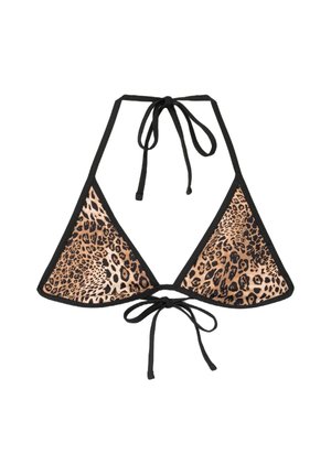 Femme aux cheveux mouillés portant un haut de bikini à imprimé léopard, regardant directement la caméra devant un mur en béton texturé.