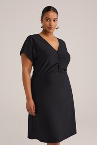 Zwarte jurk van gestructureerde stof, met een V-hals, korte mouwen en geplooide details bij de buste. Midi-lengte en recht gesneden.