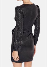 Černé mini šaty s dlouhými puff rukávy, texturovaná kovová tkanina, přiléhavý pas a detail se zipem na zadní straně. Jednoduchý, elegantní design.