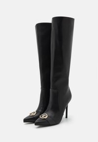 Crne čizme do koljena od glatke kože, s uskim vrhovima, visokim štiklama i zlatnim detaljima.
