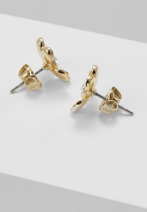 Een paar gouden oorstekers in de vorm van vlinders met zilveren pinnen en hartvormige achterkantjes op een witte ondergrond.