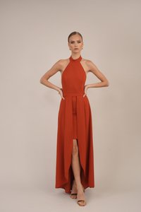 Halter neck, floor-length dress in rust orange fabric, featuring a high slit and fitted bodice, with a flared skirt and no visible patterns.
