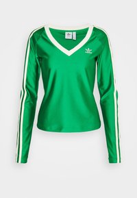 Top verde de manga larga hecho de satén, con escote en V y acentos de rayas blancas a lo largo de las mangas. Logo de Adidas en el pecho.