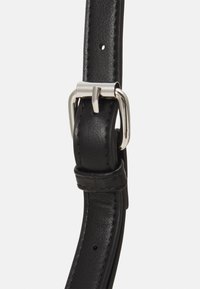 Sort læderrem med en blank sølvspænde, der har jævnt fordelte huller og en glat overflade, som fremhæver minimalistiske designdetaljer.