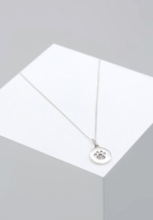 Collana d'argento con un pendente circolare che presenta un design a impronta di zampa e tre pietre incastonate. La catena è sottile e lucida.