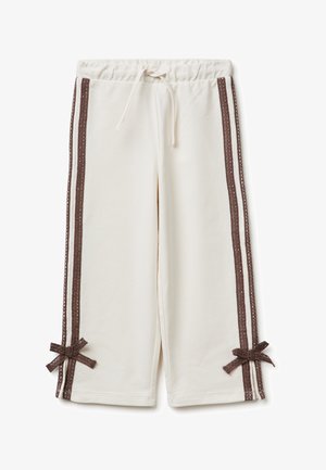 Pantaloni a gamba larga color crema con strisce laterali in pizzo marrone e fiocchi abbinati vicino all'orlo, con vita a coulisse.