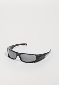 Juodos Oakley apvalios saulės akinių su tamsiais stačiakampiais objektyvais ir kreivomis rankenomis ant paprasto balto fono.