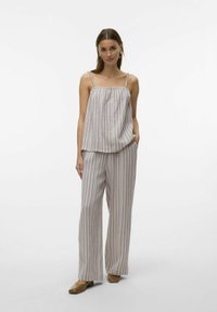 Ensemble léger en tissu rayé comprenant un débardeur ample à bretelles réglables et un pantalon large, dans des couleurs pastel douces.