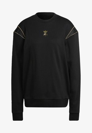 Juodas džemperis su ilgomis rankovėmis, apvaliu iškirpimu ir tinklinėmis detalėmis ant pečių. Centre yra auksu siuvinėtas logotipas.