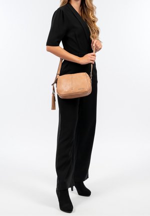 Borsa a tracolla in pelle tan con una texture liscia, design minimalista e dettagli cuciti. Presenta un accento a nappina e una tracolla regolabile.