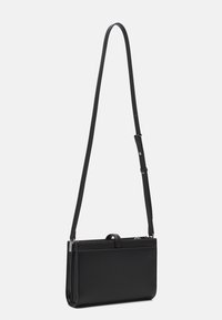 Sort læder crossbody taske med flad form, justerbar skulderrem og lynlås lukning. Har et lille top håndtag og et minimalistisk design.