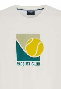 Chemise décontractée blanche avec un motif géométrique vert et beige, balle de tennis jaune et texte "RACQUET CLUB" sur le devant.