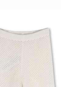 Leggings bianchi lavorati a maglia con una texture a rete e una vita elastica. Presentano piccoli fori a forma di diamante per favorire la traspirazione.