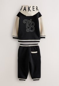 Ensemble sweat à capuche et pantalon pour tout-petit noir et crème avec "TB" dans le dos et texte "BAKER" sur la capuche, avec poignets et ceinture côtelés.