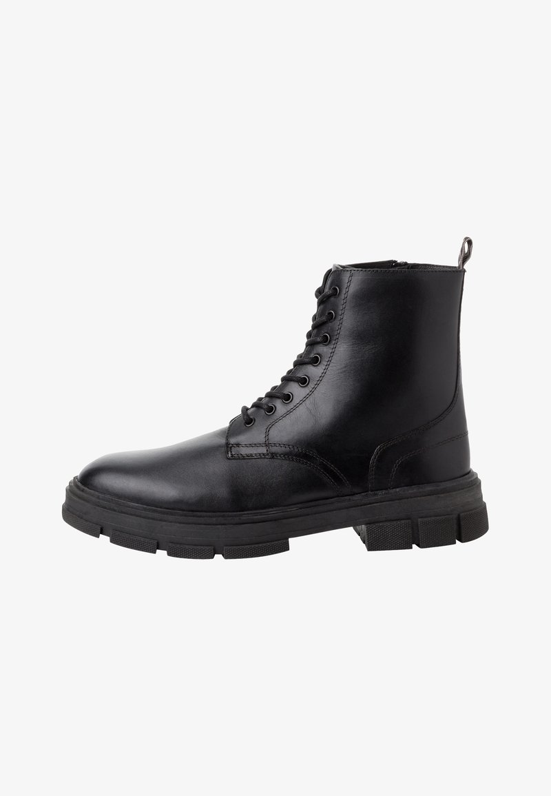 Stivale alla caviglia in pelle nera con punta rotonda, chiusura con lacci e suola in gomma spessa. Presenta dettagli di cucitura e una linguetta sul tallone.