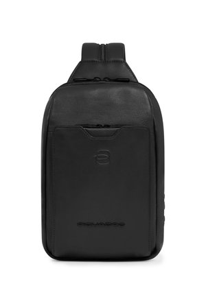 Zwarte leren schouderrugzak met ritsvak aan de voorkant, geperst logo en verstelbare gewatteerde band zichtbaar aan de bovenkant.