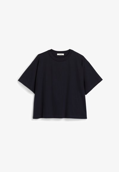 Tamsiai mėlyna trumpomis rankovėmis marškinėliai pagaminti iš minkštos medvilnės, pasižymintys laisvu siluetu, apvaliu kaklu ir minimalistiniu dizainu. Be matomų raštų ar akcentų.