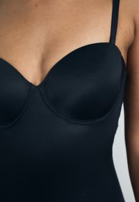 Black swimwear featuring a fitted, smooth fabric with a structured, padded bust and thin straps, showcasing a v-shaped neckline.