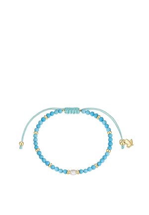 Adjustable bracelet with turquoise and gold beads, a central white pearl, and a small gold bird charm on a light blue cord.