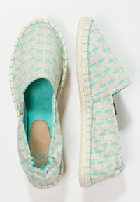 Espadrillas azzurre chiare con uno sfondo crema e un motivo ripetuto, tessuto testurizzato e suola in juta intrecciata.