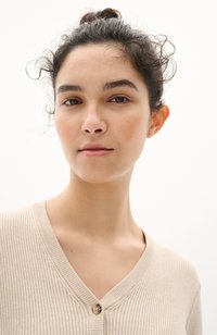 Cardigan beige a coste con scollatura a V e chiusura a un bottone, caratterizzato da una texture morbida e dettagli sottili lungo i bordi.