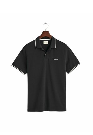 Sort polo-shirt med hvide accenter på kraven og ærmerne. Har en to-knaps lukning og broderet logo på brystet. Textureret stof.