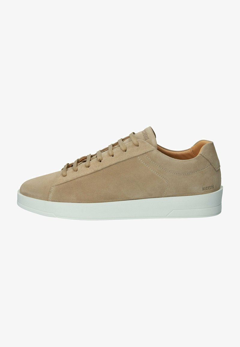 Beige Wildleder-Sneaker mit weißer Gummisohle. Merkmale sind eine glatte Textur, eine abgerundete Zehenpartie und ein minimalistisches Schnürdesign. Branding an der Seite.