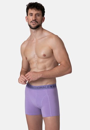 Fialové boxerky vyrobené z mäkkého materiálu s čiernym elastickým pásom, na ktorom je v šedej farbe názov značky "MUCHACHOMALO".