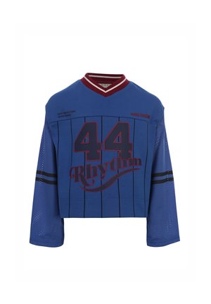 Blauw cropped sportshirt met lange mouwen, rode en zwarte strepen, nummer 44 en het woord Rhythm op de voorkant gedrukt.