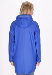 Zils ūdensnecaurlaidīgs lietussargs ar kapuci, ar teksturētu apdari, garām piedurknēm un nedaudz brīvu piegriezumu. Mugurā redzama vienkārša drukāta frāze.