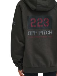 Schwarzer Hoodie mit Kapuze, rote Zahlen "223" über "OFF PITCH" und Koordinaten "Breitengrad: 55.702668 | Längengrad: 12.5724" auf dem Rücken.