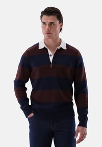 Marineblauer und burgunderfarbener gestreifter Pullover mit weißem Kragen, Knopfleiste sowie gerippten Bündchen und Saum. Das Material wirkt weich und strukturiert.