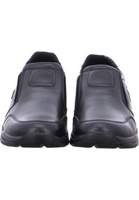 Schwarze Leder-Slipper mit runder Zehenform, strukturiertem Sohlenprofil und seitlichen Einsätzen. Sie zeichnen sich durch minimale Nähte und eine glatte Oberfläche aus.