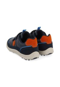 Zapatillas deportivas en azul marino y naranja con una parte superior lisa, acentos azules, un talón texturizado y una suela blanca robusta diseñada para la comodidad.