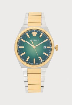 Montre-bracelet en métal doré et argenté avec cadran vert, index dorés, trois aiguilles, guichet date et logo Versace sous 12 heures.