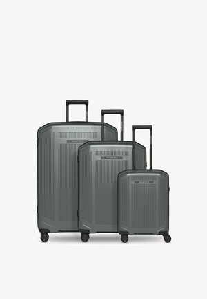 Trois valises rigides grises de tailles différentes avec des poignées noires extensibles et quatre roues pivotantes, portant la marque "SMARTBOX" à l'avant.