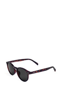 Kulaté sluneční brýle s tmavým želvovinovým rámem, černými skly a jemnými tečkovanými detaily na stranicích. Elegantní, lehký design.