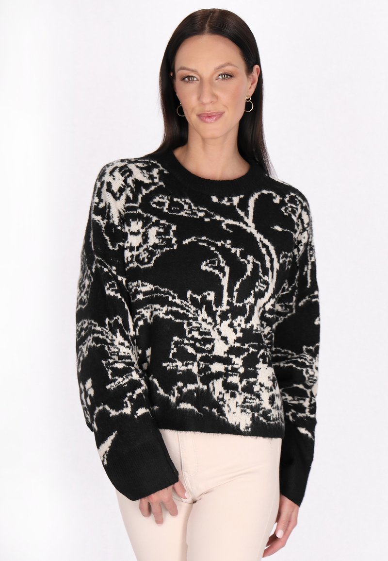 Pulover tricotat floral alb-negru cu mâneci lungi, guler rotund și model texturat; talie ajustată și croială lejeră.