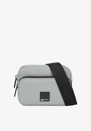 Bolso bandolera de color gris claro, fabricado en material texturizado, con dos compartimentos con cremallera y una correa ajustable negra con detalle de logotipo.