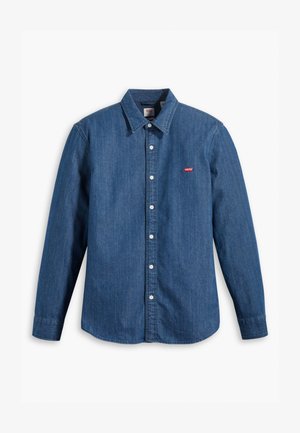 Camisa de mezclilla azul oscuro con mangas largas, cuello con solapa y cierre de botones. Presenta un pequeño logo rojo de Levi's en el pecho. Textura suave.