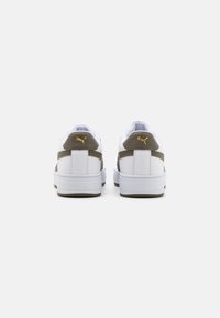 Sneaker bianche con una tomaia in pelle liscia, dettagli in suede grigio e un logo dorato sul tallone. Suola piatta in gomma con battistrada testurizzato.