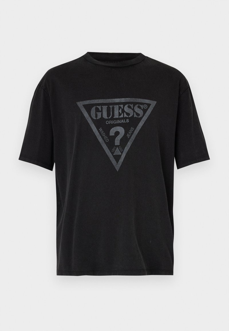 Svart kortärmad t-shirt i bomull med en triangelgrafik som har "GUESS ORIGINALS" och ett frågetecken i mitten.