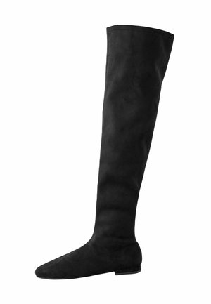 Black flat over-the-knee boot with a rounded toe and soft suede texture, shown in side profile on white background.
