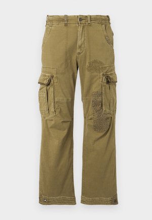 Olive green cargo pants with multiple pockets, featuring a patterned patch on the right leg and reinforced stitching. Casual fit and fabric texture.