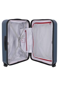 Valigia rigida di colore blu con interno apribile a zip. Presenta una fodera a righe, cinturini regolabili, una tasca in rete e dettagli rossi.