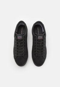 Baskets en toile noires avec bout rond, conception à lacets, surface texturée et intérieur rayé contrasté. Logo présent sur la languette et sur le côté.