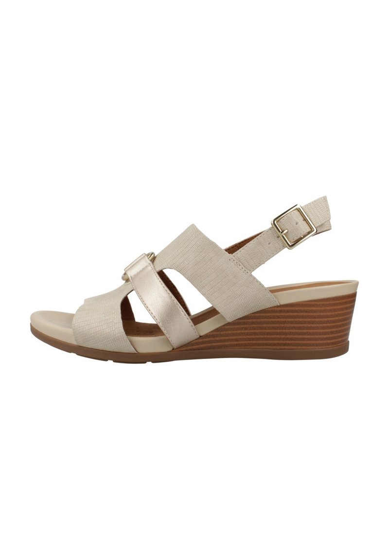 Sandalias de cuña beige con un upper de tela texturizada, tiras cruzadas anchas, acentos metálicos y una hebilla ajustable en la tira del talón.