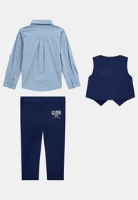 Chemise à manches longues bleu clair avec de petits motifs bleu marine, gilet marine et pantalon marine avec le logo "GUESS" sur la jambe. Texture lisse.