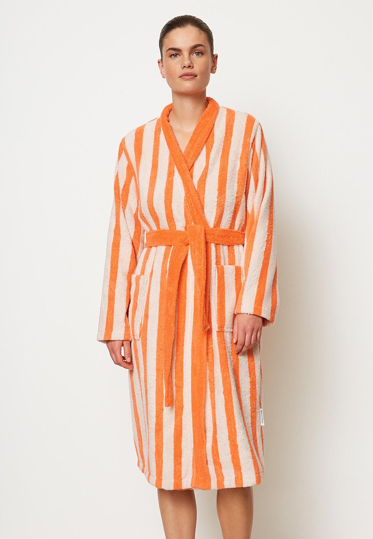 Peignoir rayé orange et blanc en tissu éponge texturé, avec des manches longues, une taille ceinturée et deux poches latérales.