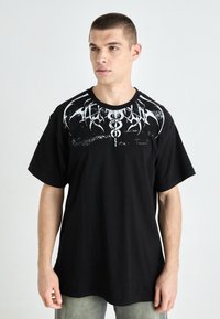 Black short-sleeve t-shirt with a graphic design in white on the chest, featuring abstract patterns and a textured finish.
